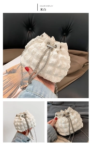 Detail of off-white bubble pleated bucket bag with silver metal chain and beaded base