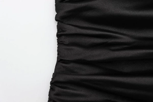 Close-up of black satin fabric showing premium pleat details and elegant silky texture