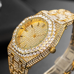 Macro shot of iced-out gold watch featuring an octagonal bezel with full crystal pavé