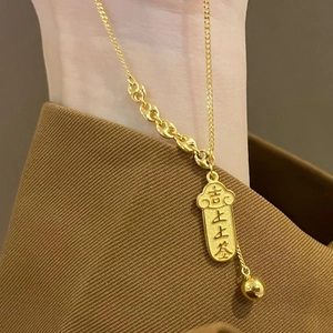 Goldene Titanstahl-Halskette mit chinesischem Glücksanhänger am Handgelenk des Models