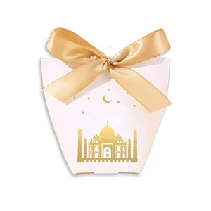 Detailed view of white candy gift box with golden castle pattern and satin ribbon bow