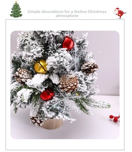 Miniature flocked Christmas tree with red bells, pine cones and a rustic wooden base