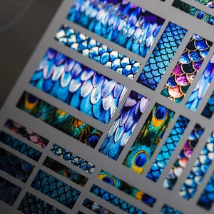 Adhesive nail art stickers with laser metallic peacock feather and fish scale patterns