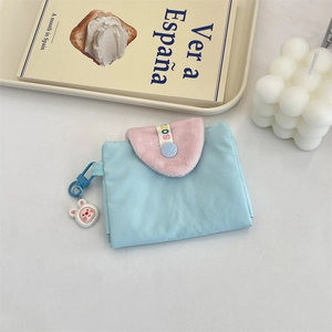 Détail d'un porte-cartes en tissu bleu avec rabat peluche rose et pendentif lapin
