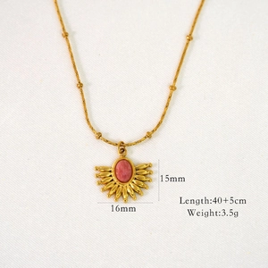 Detail view of vintage sunburst pendant with pink rhodochrosite and golden chain specs
