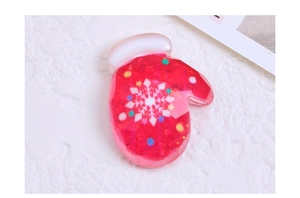 Macro shot of a red resin glove accessory with glitter and snowflake pattern for DIY crafts