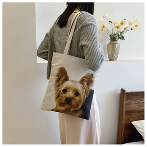 Detailed side view of a beige canvas tote bag featuring a realistic Yorkshire Terrier print