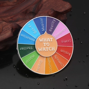 Close-up of a rotating enamel pin showing diverse movie genres and what to watch wheel