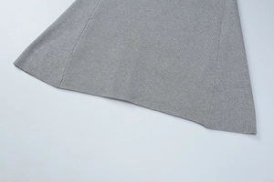 Close-up of grey ribbed knit fabric texture and high-quality seam detail on dress
