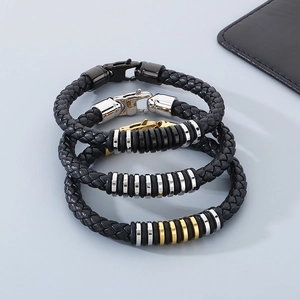 Detail view of woven black leather bracelets with mixed silver, gold, and black steel rings