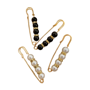 Set of four geometric pearl brooches in gold and black with sparkling rhinestone accents