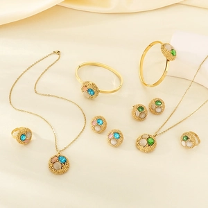 Golden jewelry set with round pendants and multi-color gemstones on champagne silk background