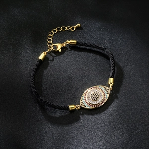 Détail macro du bracelet Oeil de Turquie avec zircons colorés sur texture cuir noir