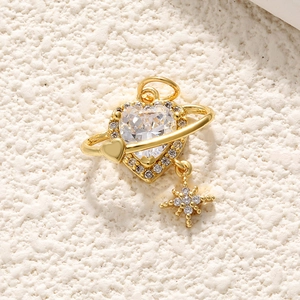 Macro shot of 18K gold heart pendant with planet ring and sparkling zircon star