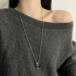 Détail d'un long collier en argent avec pendentif en pierre naturelle noire