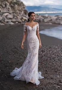 Close-up of elegant off-shoulder lace wedding dress with leaf patterns and champagne lining