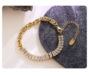 Detail of 18K gold plated chain bracelet with rectangular zircon stones on a grey mat