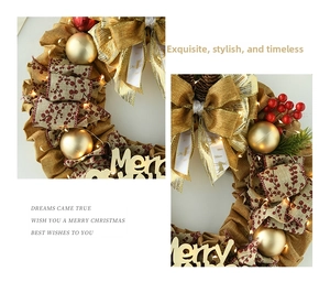 Close-up of golden linen Christmas wreath with warm LED lights and red berries decoration
