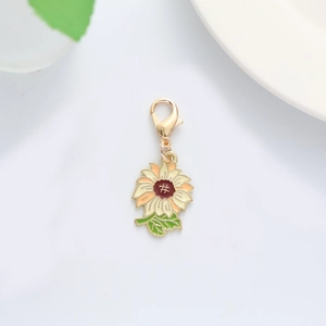 Macro shot of gold-plated sunflower keychain charm with vibrant enamel flower petals