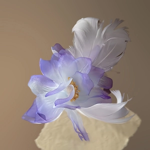 Detailed close-up of handmade purple floral hair clip with soft white feathers and petals