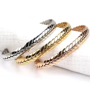 Detail of woven wheat pattern cuff bracelets in silver, gold, and rose gold finishes