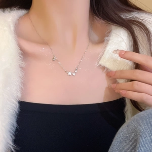 Detail of silver titanium steel necklace with star pendants on model neck