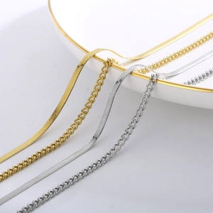 Macro detail of gold and silver snake and curb chain textures on a porcelain plate