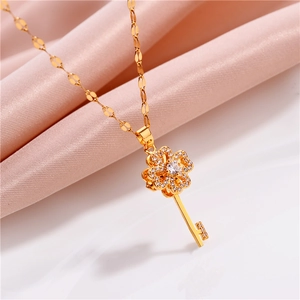 Rotating key pendant necklace in gold with zircon clovers on elegant pink silk
