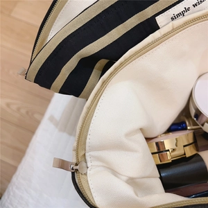 Detail view of cotton striped cosmetic bag interior showing makeup storage and zipper