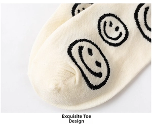 Detailed close-up of smooth toe seam on off-white cotton socks with black smiley face