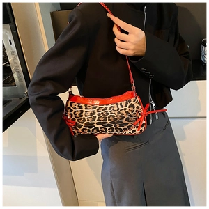 Close-up of leopard print handbag with red leather trim and side bow details
