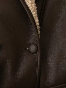 Dettaglio giacca in pelle marrone scuro con interno in pile crema e bottone abbinato