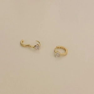 Close-up of heart-shaped zircon crystal on gold-plated sterling silver hoop earrings