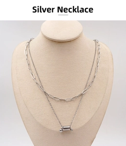 Detail view of silver double-layer paperclip chain with a cylindrical screw pendant