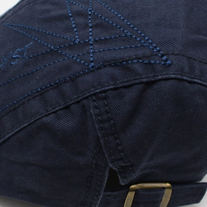 Detail of dark blue cotton baseball cap with star embroidery and bronze metal buckle