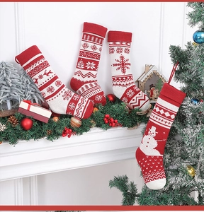 Dettaglio di calze di Natale in maglia con renne e fiocchi di neve appese al camino