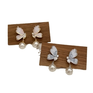 Elegant butterfly drop earrings with gradient crystal wings and hanging pearls on wood