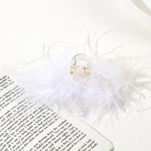 Detail shot of a transparent plastic hair claw clip with elegant white ostrich feathers