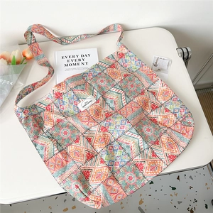 Artistic oil painting floral canvas tote bag displayed on white desk with decor