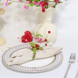 Close-up of heart-shaped berry napkin ring on a beige linen napkin for romantic table setting