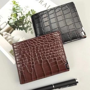 Detail of crocodile pattern leather wallets in black and dark brown with a luxury finish