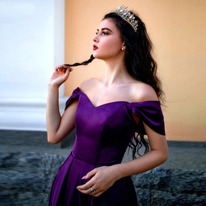 Detail of elegant deep purple satin dress with pleated off-shoulder heart neckline