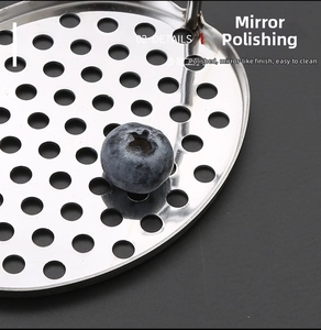 Detail of mirror-polished stainless steel perforated disc with precise circular holes