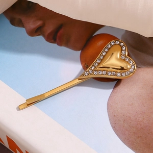 Detailed view of an 18K gold-plated heart hair clip with sparkling crystal border