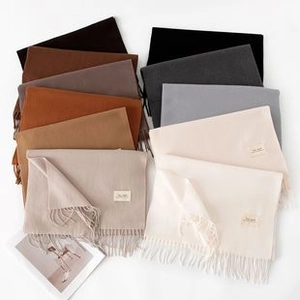 Flat lay of colorful houndstooth scarves with fringes in neutral and earthy tones