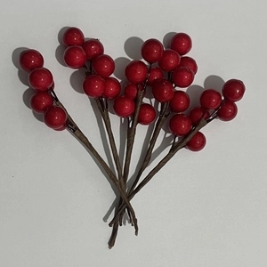 Detailed view of artificial red berry branches with glossy finish for wedding candy boxes