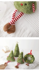 Dettaglio di bambole natalizie in peluche verde con lunghe gambe a righe e stelle