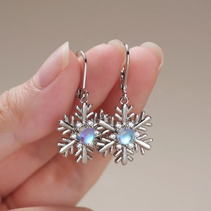 Détail de boucles d'oreilles flocon avec pierre de lune bleue et crochets en argent