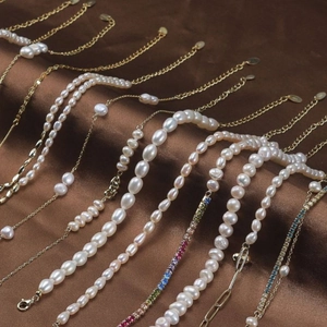Selection of S925 sterling silver natural pearl necklaces on elegant brown silk