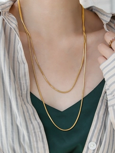 Detailed view of long 18K gold-plated square snake bone chain necklace on model.